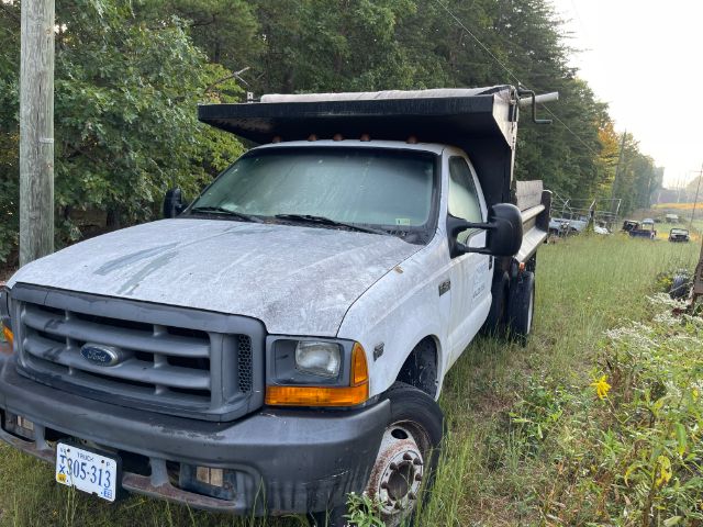 2000s Ford F-450 dump truck in field with lifted bed and front grille visible, VIN 3FDXF46S5XMA17764 on listing