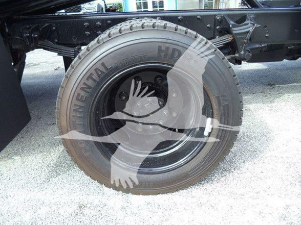 Truck wheel showing Continental HD tire and black steel rim with hub area and suspension components.