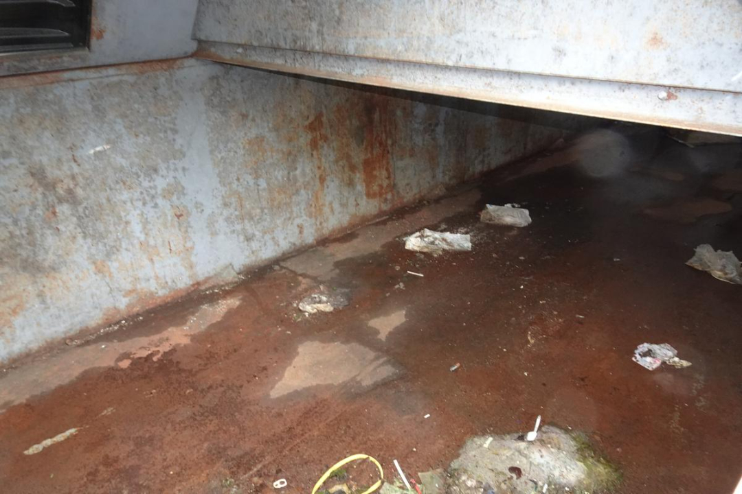 Wastequip 20 yd truck body interior showing rusted steel bed and dirty floor with debris.