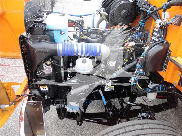 Engine bay of a 2022 Peterbilt 337 showing coolant reservoir, air intake hose, and various hoses and components.