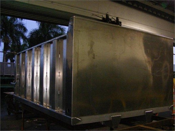 Dump body truck bed showing polished stainless steel panels and rear access.