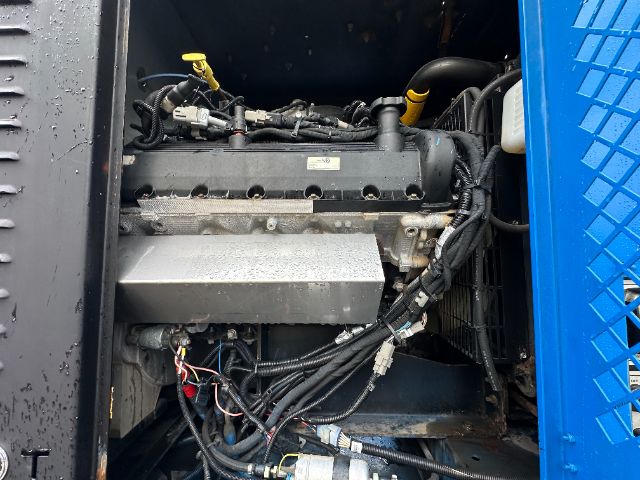Mack GU713 engine bay with visible diesel engine components, hoses, wiring harness, and metal intake housing.