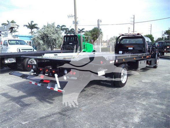 2025 Ford F750 XLT flatbed tow truck rear view showing dual rear wheels and flatbed with warning lights.