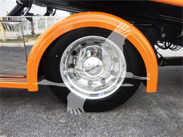 Peterbilt 337 wheel well and chrome rim with orange fender, front-left side of truck.