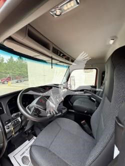 Kenworth T880 truck interior showing steering wheel, dashboard, and driver seat in a cab with overhead storage.