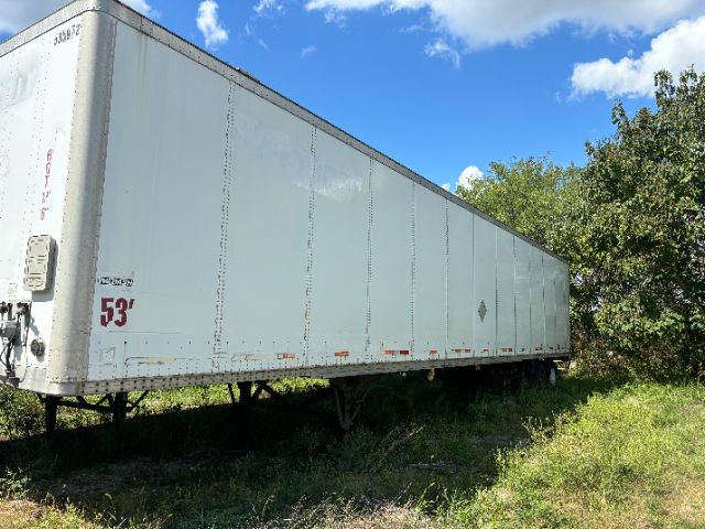 A 53-foot Wabash trailer in a grassy lot showing a side view with light blue exterior and red 53' marking near the front corner.