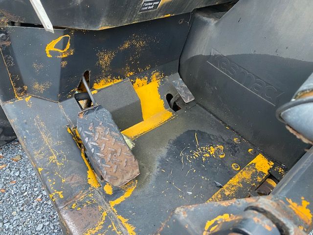 Kesmac F5000 forklift foot pedal area with textured pedal and yellow painted surface, showing operator area and worn yellow paint.