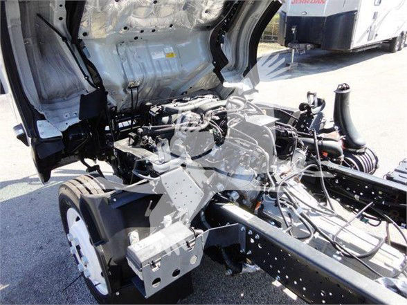 Isuzu NPR HD truck chassis and engine bay with cab removed, showing frame rails, suspension, and exposed engine area.