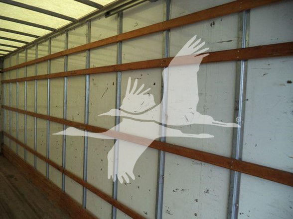 Image shows interior of a box truck trailer with metal walls and horizontal wooden ribs; faint logo of flying geese overlay.