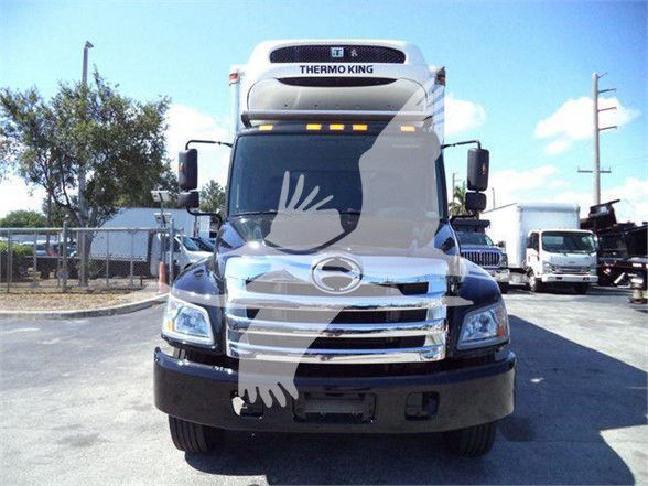 Front view of a refrigerated box truck with Thermo King unit on cab roof, chrome grille, and large bumper.
