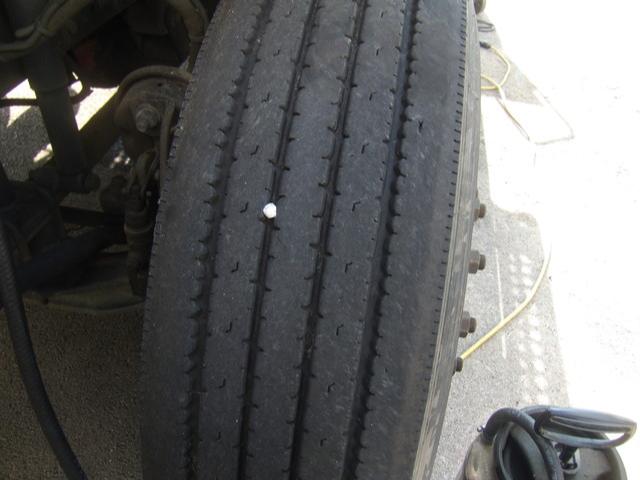 Truck tire tread close-up on Freightliner Columbia conventional daycab showing wheel and part of suspension.