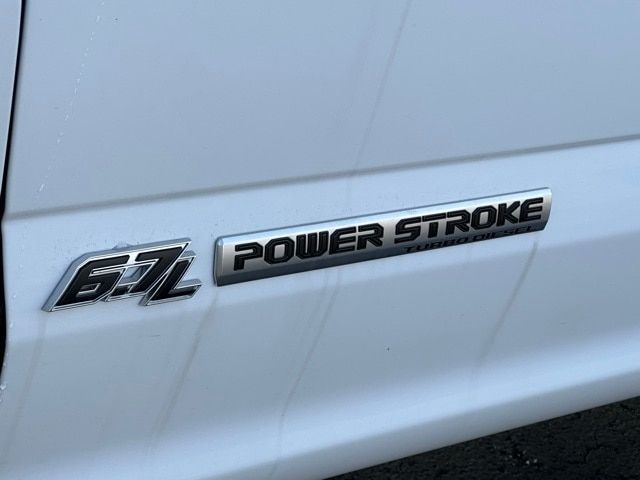 Ford F-550 Power Stroke badge on white truck side panel (57L), showing 'POWER STROKE' emblem.