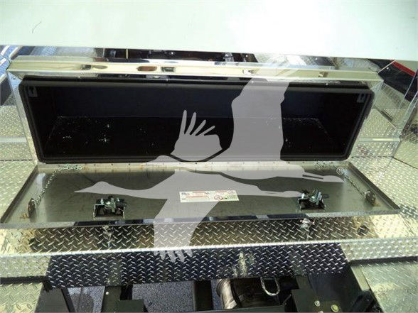 Truck compartment storage box in open position with diamond plate metal surface.