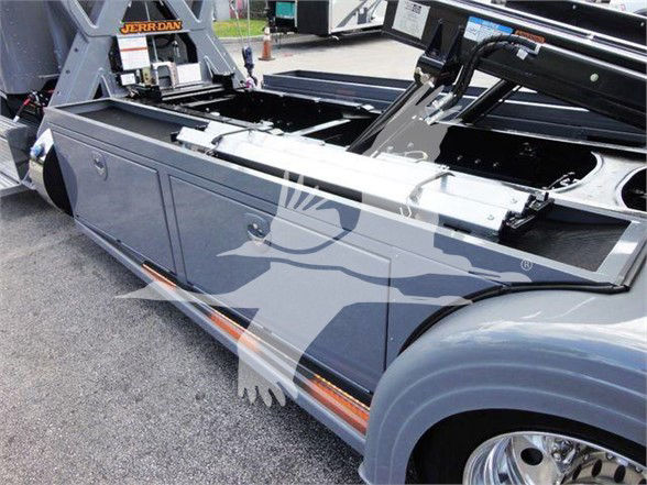Peterbilt 337 tow truck side view with bed compartment and hydraulic equipment visible.