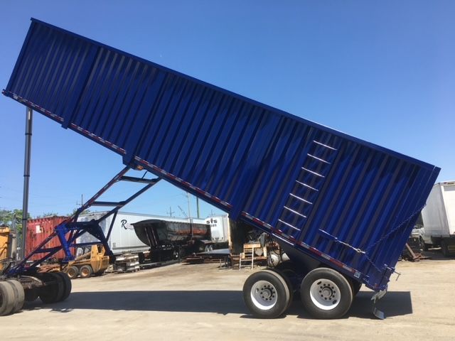 Utility 40 ft square dump trailer tilted at a 45-degree angle with dual rear axles in blue color.