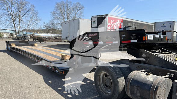 Fontaine N20 lowboy trailer with pony motor and long flatbed, parked outdoors with dual rear axles and equipment in background.