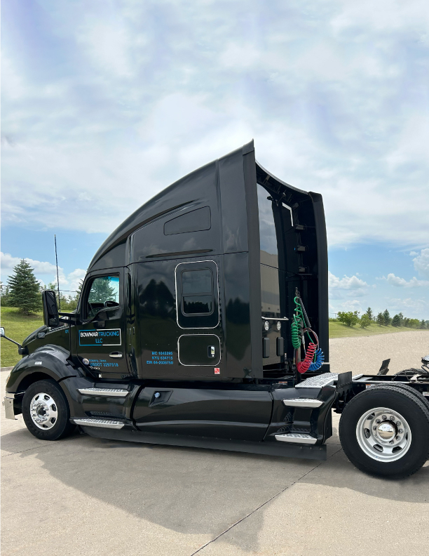 Kenworth T680 semi-truck in black exterior with sleeper cab side view showing air lines and rear chassis.