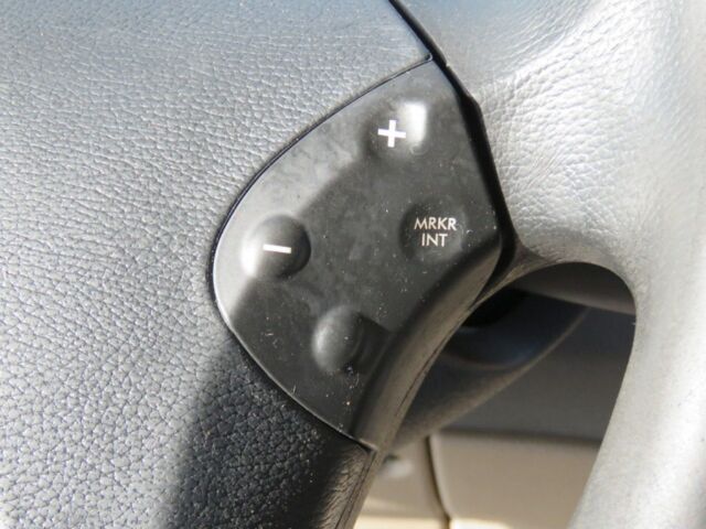 Steering wheel controls showing plus and minus buttons and MRKR INT inscription on black panel attached to steering wheel.