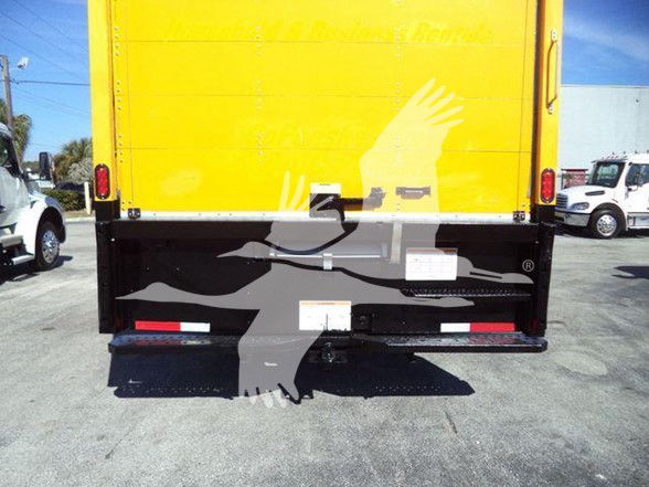 Rear view of a yellow box truck with black lower rear bumper and white/gray graphic. Tail lights, bumper steps, and small white labels visible.