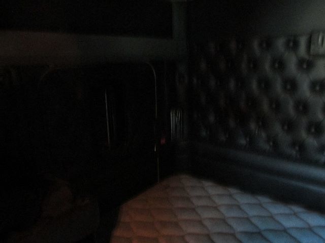 No visible text due to dark interior; back of a truck cabin with quilted seat cover and dark wall paneling.