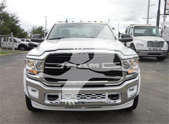 Ram 5500 HD SLT front view showing bold grille and bumper, white paint, RAM lettering on grille, daytime running lights.