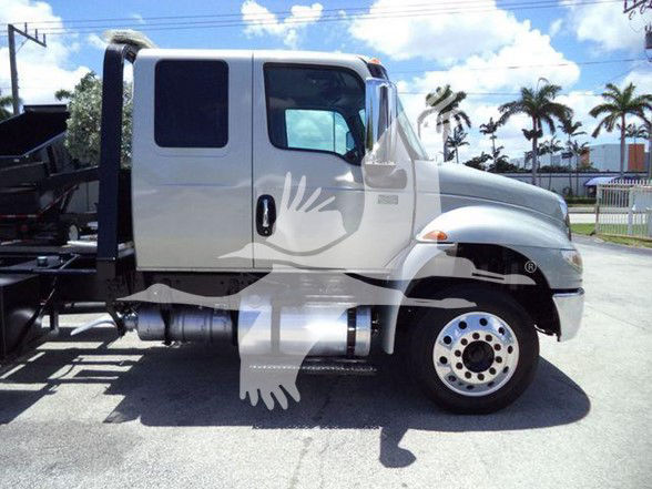 Truck cab side view shows 2022 International MV tow truck with white body, black steps, dual rear wheels, and large fuel tank; watermark overlay on image.