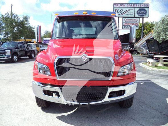 International MV truck front view showing large chrome grille, red cab, and black bumper with two lower air intakes.