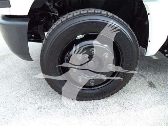 Truck front wheel with tire and hub; visible text on tire sidewall, including brand and tire specifications.