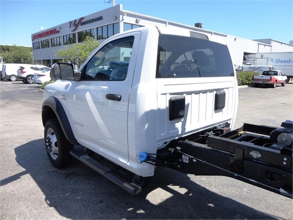 Ram 5500 HD hooklift truck cab rear view showing white body and chassis with side steps and blue tow hook.