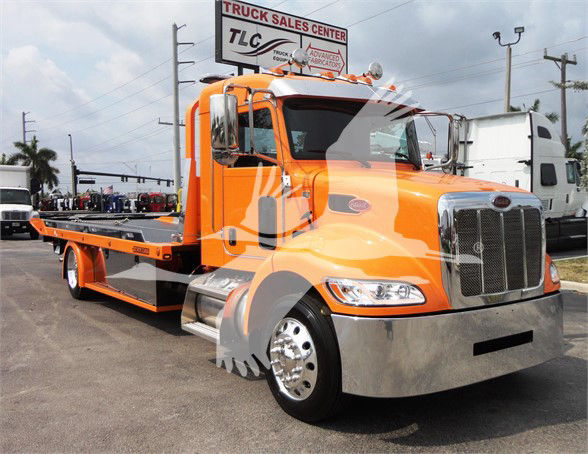 Orange 2022 Peterbilt 337 tow truck with flatbed and chrome grille, front view