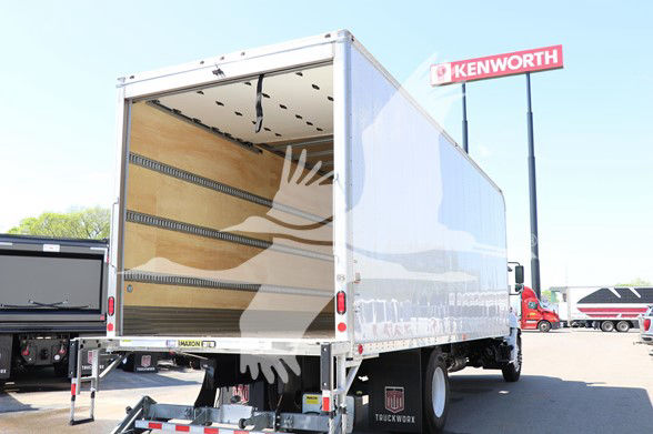 2025 Hino L6 cab and chassis box truck rear open cargo area and Kenworth dealership sign in background
