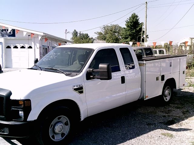 2008 Ford F-250 Super Duty utility service truck in white with service body and side compartments.