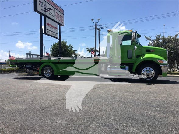 Peterbilt 337 tow truck in green with flatbed, side profile view, stock number J52310.