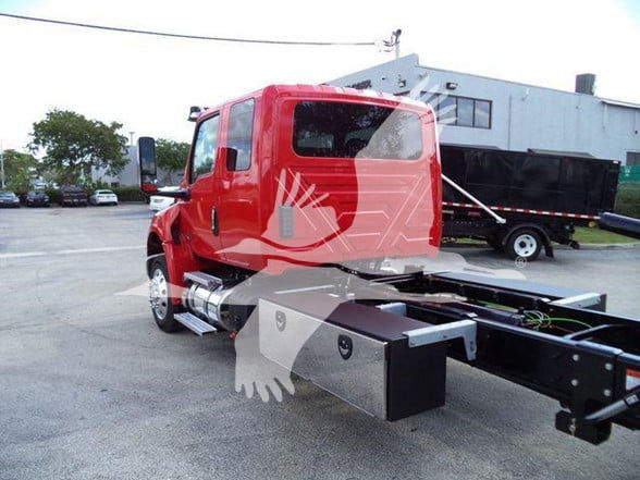Red International MV truck chassis cab side view with fuel tanks and frame rails visible.