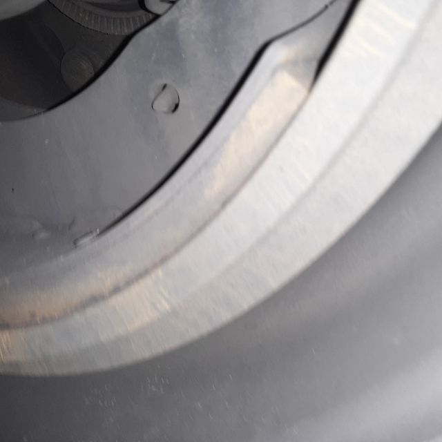 Wheel and tire close-up on a Fontaine Revolution 52 flatbed trailer wheel rim area.