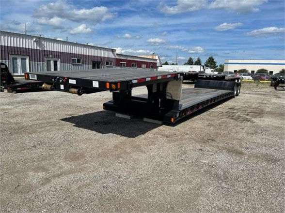 Fontaine Renegade 18 LX40 low-boy trailer showing long flatbed with dual rear axles and rear ramps in an outdoor lot.