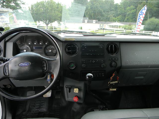 Ford F-750 Super Duty crew cab interior dashboard and steering wheel showing factory gauges and gear shift.