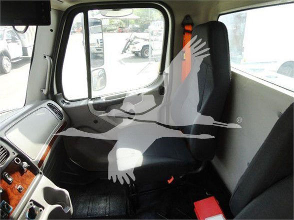 Cab interior of Freightliner Business Class M2 106 showing driver seat and dashboard area with wood grain panel.