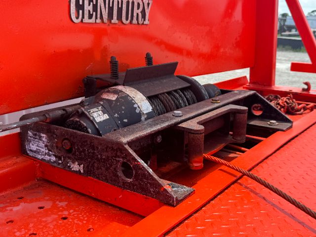 Winch motor and rope on red tow truck body with Century branding visible.