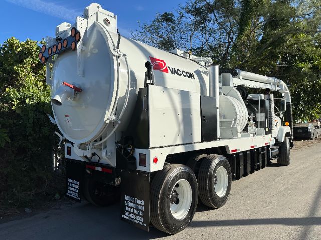 Vaccon brand vacuum truck showing rear compressor unit and tail lights, side view with multiple axles and white cab.