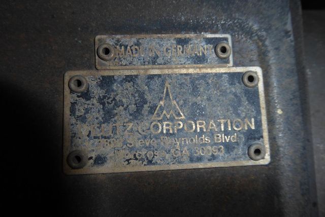 Plate on Bomag BW212D-2 with 'MADE IN FRANCE' and 'CORPORATION' text, showing worn metal plate with screws. Visible text: 'MADE IN FRANCE' top label, below a logo, 'CORPORATION' and an address line partially readable: '... Reynolds Blvd ...