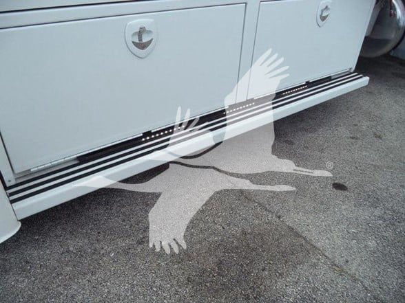 Side view of a white Peterbilt 337 truck with service compartments and running boards. No visible model text clearly readable in the image.