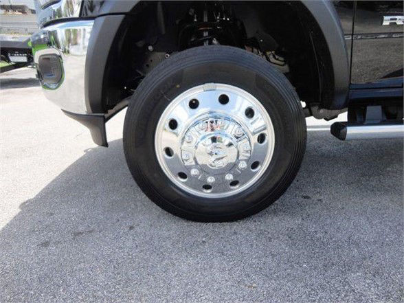 Wheel and tire of a 2024 Ram 5500 SLT showing chrome hubcap with lug nuts and tire sidewall.