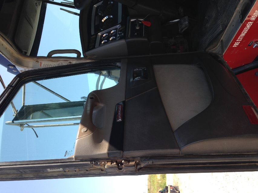 Kenworth T800 truck interior door area showing steering console and dash, with open door