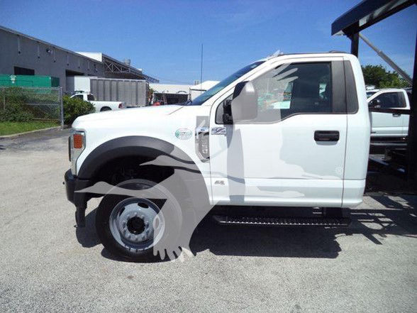 Ford F-550 cab view showing front fender and side step with wheel, white cab, side mirror, and door.