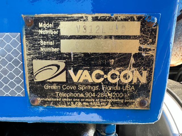 Label plate on blue Vac-con unit showing Model Number V312L? and Serial Number, with Vac-con logo and address in Florida.