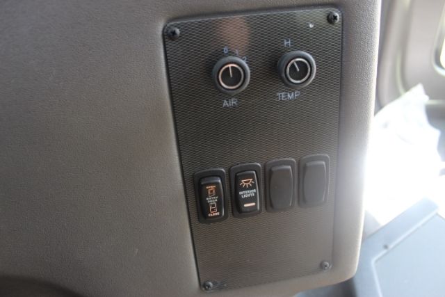 Control panel with AIR and TEMP dials and several switches in a bus interior.