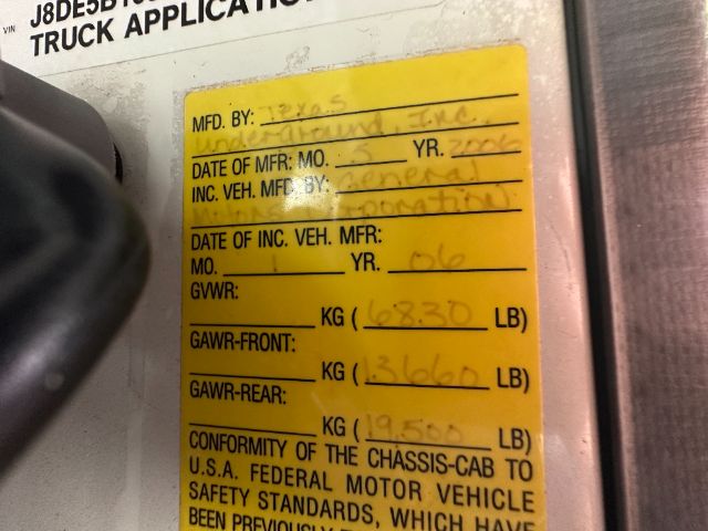 Yellow MFG plate with handwritten fields on GMC W5500, including MFD BY, DATE OF MFR, GVWR, GAWR front/rear, and weights in KG/LB.