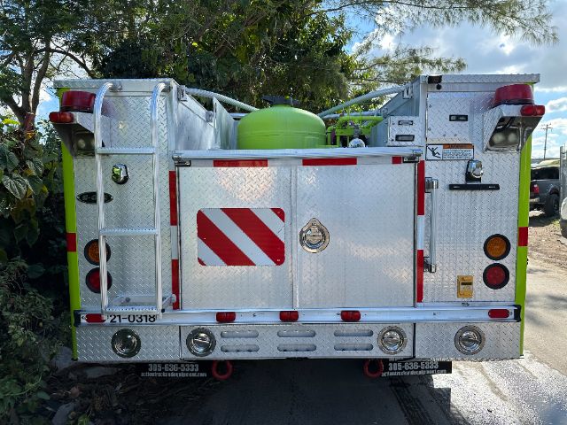 Back of a 2001 Ford F550 fire truck with silver diamond plate and green equipment compartments.