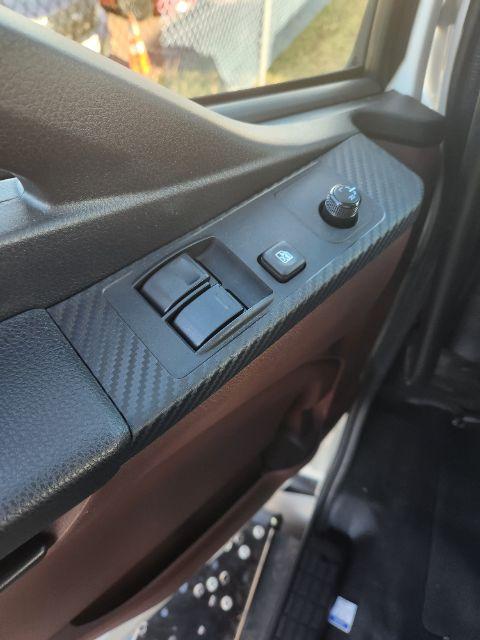 Interior door panel showing power window switch and mirror control dial in a Hino truck.